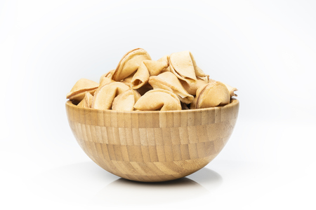 Fortune cookies in the wooden bowl isolated over white backgroundの写真素材