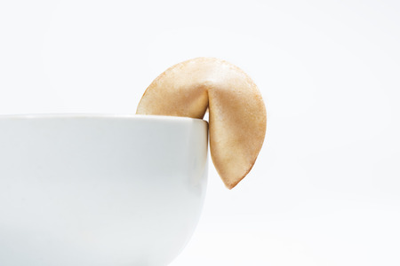 Fortune cookies on edge of the bowl for dessert dish isolated over white backgroundの写真素材