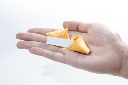 Fortune cookies with empty quote on human hand isolated over white backgroundの写真素材