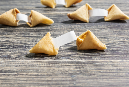 Fortune cookies with blank paper on the wooden tableの写真素材