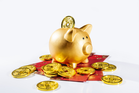 Piggy bank standing on red envelopes with golden coin isolated over white background. Chinese New Years. Year of the earth pigの写真素材