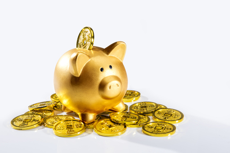Piggy bank standing on pile of golden coins isolated over white background. Chinese New Years. Year of the earth pigの写真素材