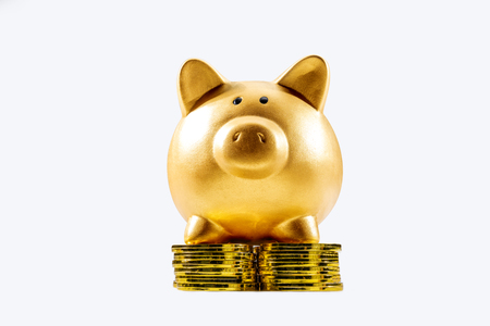 Piggy bank standing on the stack of golden coin isolated over white background. Chinese New Year. Year of the earth pigの写真素材