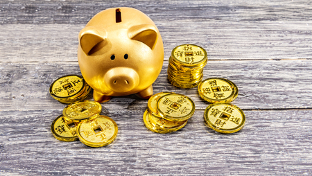 Piggy bank and golden coins on the wooden table. Chinese New Year. Year of the earth pigの写真素材