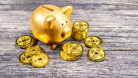 Piggy bank and golden coins on the wooden table. Chinese New Year. Year of the earth pigの写真素材