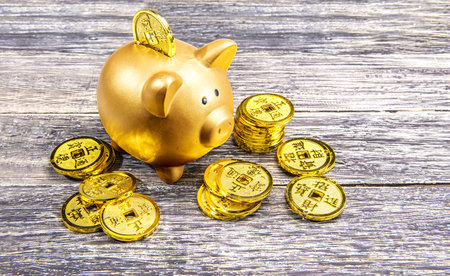 Piggy bank and golden coins on the wooden table. Chinese New Year. Year of the earth pigの写真素材