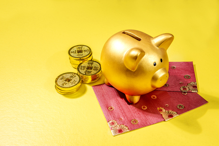 Piggy Bank With Golden Coins And Red Envelopes Over Yellow
