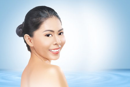 Young asian woman with fresh skin and beautiful face over blue background. Skin care conceptの写真素材