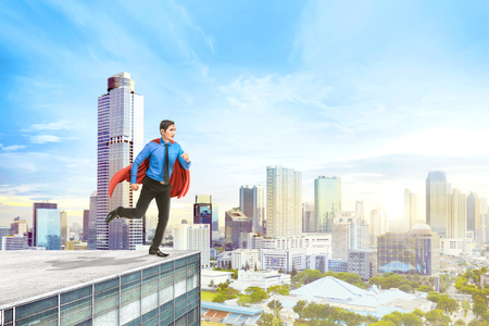 Attractive asian superhero businessman ready to fly to the skyの写真素材