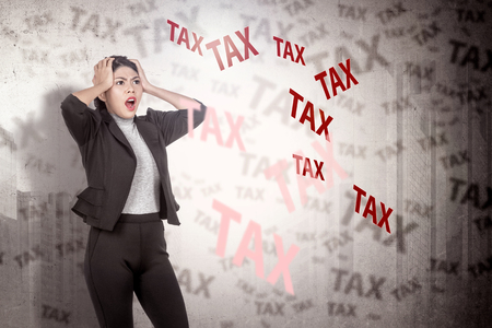 Pretty asian business woman feeling stressed with taxes. Taxes conceptの写真素材