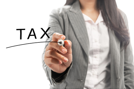 Business woman with marker write tax text on transparent board. Taxes conceptの写真素材