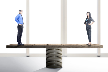 Asian businessman and businesswoman standing on balancer. Equality gender conceptの写真素材