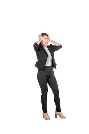 Stressed asian business woman pulling her hair posing isolated over white backgroundの写真素材