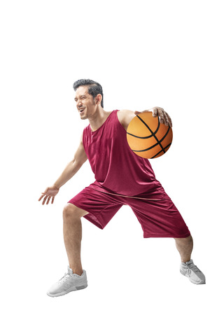 Attractive asian man playing basketball in action posing isolated over white backgroundの写真素材