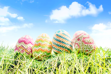 Colorful easter eggs on the green grass with blue sky background. Happy Easterの写真素材