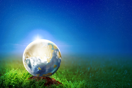 Earth on the soil in meadow at night with star on the sky background. Earth hour conceptの写真素材