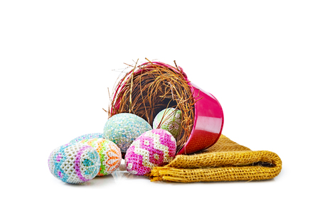 Colorful easter eggs spilled from nest in red bucket with fabric isolated over white background. Happy Easterの写真素材