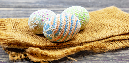 Close up view of Colorful easter eggs on the fabric with wooden table background. Happy Easterの写真素材