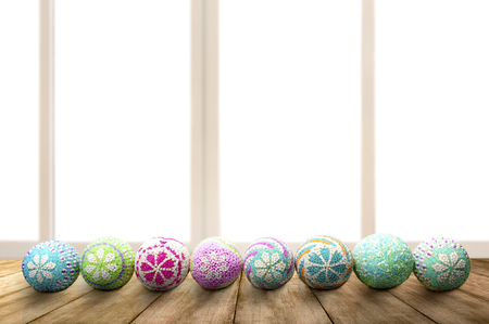 Row of Colorful easter eggs on wooden table with window glass background. Happy Easterの写真素材