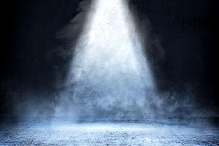 Room with concrete floor and smoke with light from the top against dark wall backgroundの写真素材