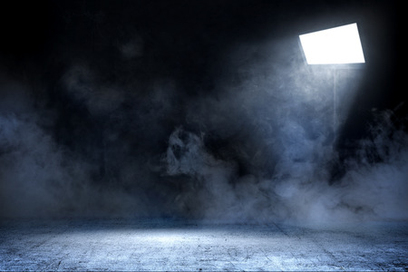 Room with concrete floor and smoke with light from spotlights against dark wall backgroundの写真素材