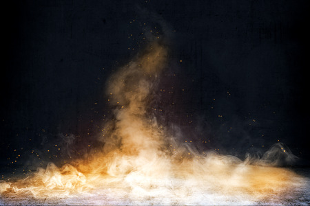 Room with concrete floor and smoke with fire sparks with dark wall backgroundの写真素材