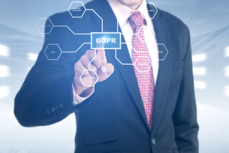 Hand of businessman pointing at shield with keys icon and GDPR text button with protection structure on virtual screen. Cyber security and privacy. General Data Protection Regulation (GDPR) conceptの写真素材