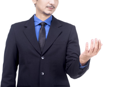 Smiling asian businessman in suit standing with open palm for holding or showing something isolated over white backgroundの写真素材