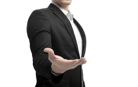 Businessman in suit standing with open palm for offer shake hands and holding or showing something isolated over white backgroundの写真素材