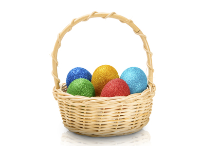 Colorful easter eggs with glitter on wooden basket isolated over white background. Happy Easterの写真素材