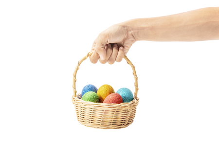 Human hands holding wooden basket with colorful easter eggs isolated over white background. Happy Easterの写真素材