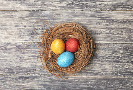 Colorful easter eggs in the nest on wooden table. Happy Easterの写真素材