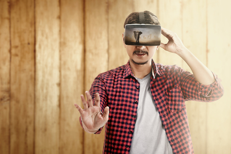 Asian man looking at blurry wild animals with virtual reality device. Augmented reality technologyの写真素材