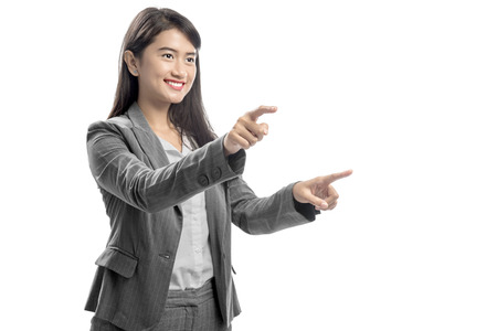 Portrait of asian business woman touching something with her finger posing isolated over white backgroundの写真素材
