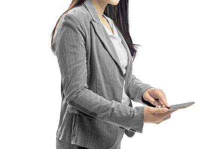 Business woman touch the mobile phone screen posing isolated over white backgroundの写真素材