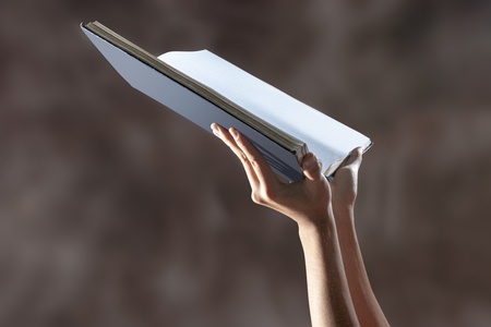 Muslim hands holding quran open over blurry backgroundの写真素材