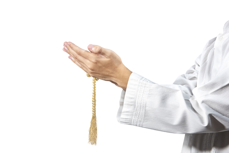 Muslim man praying with prayer beads on his hands isolated over white backgroundの写真素材