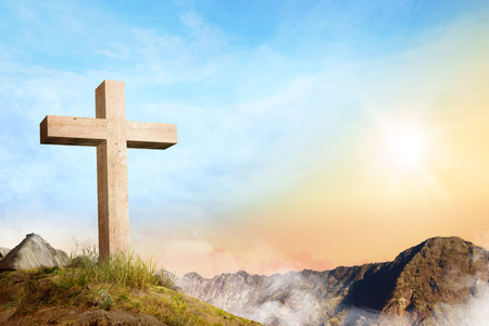 Christian cross on the of mountain with clouds fog over sunrise backgroundの写真素材