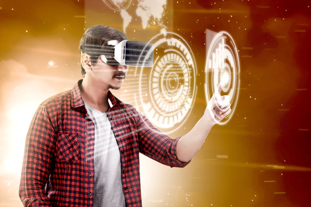 Asian man touching a circle on digital interface with virtual reality device display the world map and binary code. Augmented reality technologyの写真素材