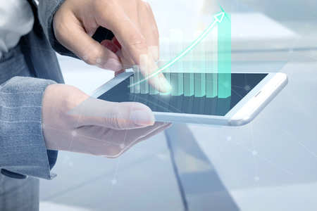 Business woman touch the digital tablet and display the interface of incrased graphs. Digital technology conceptの写真素材