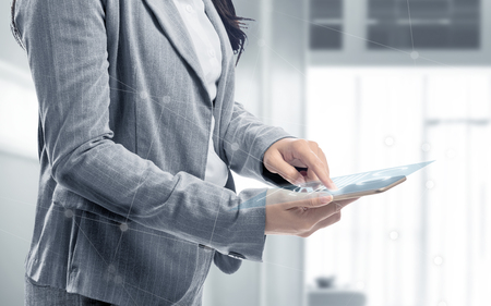 Business woman touch the digital tablet and display the interface of chart and graphs. Digital technology conceptの写真素材