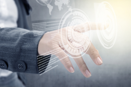Closeup view of business woman touch a circle on virtual screen which display the interface of world map and binary code. Digital technology conceptの写真素材
