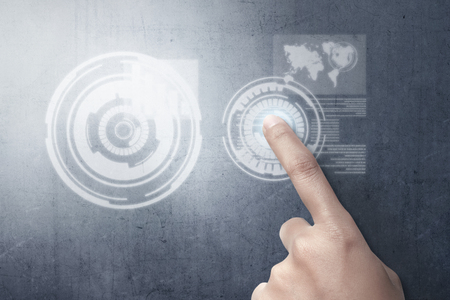 Finger of business person touch a circle in virtual screen on the wall which display the interface of world map and binary code. Digital technology conceptの写真素材