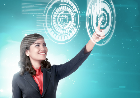 Pretty asian business woman touch a circle in virtual screen which display the interface of graph and binary code. Digital technology conceptの写真素材