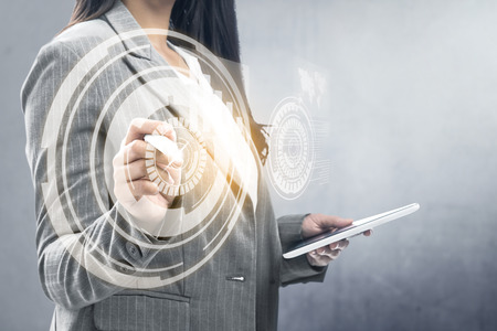 Business woman holding digital tablet and drawing with marker on virtual screen which display the interface of world maps and binary code. Digital technology conceptの写真素材