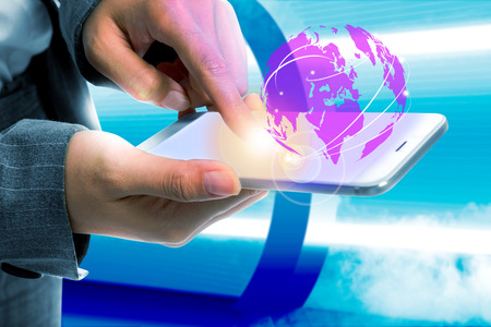 Business woman touch the mobile phone and display the interface a globe with link connection. Future technology conceptの写真素材