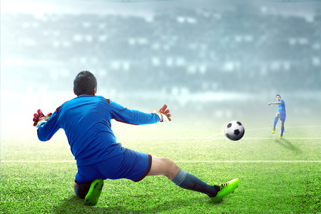 Asian football player man kicking the ball to the goal on football field at stadiumの写真素材