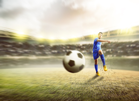 Asian football player man kicking the ball on football field at stadiumの写真素材