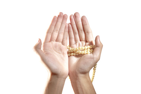 Muslim hands praying with prayer beads isolated over white backgroundの写真素材