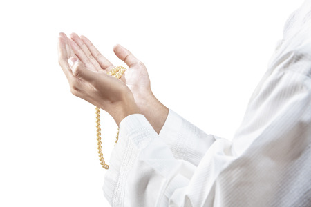 Muslim man praying with prayer beads on his hands isolated over white backgroundの写真素材